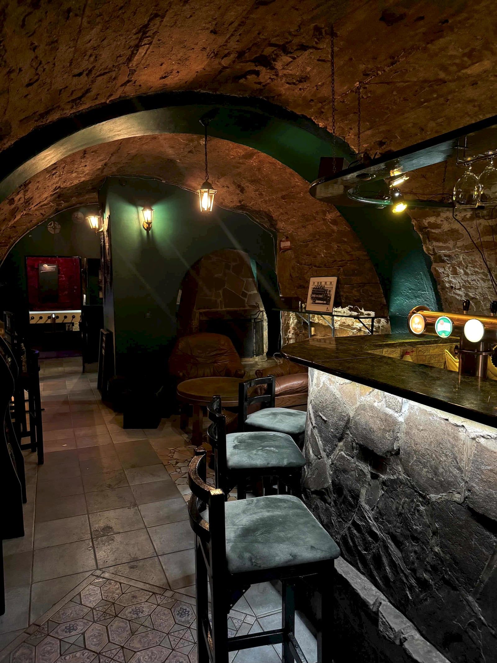 Bar a kreslá pri krbe pod kamennou klenbou